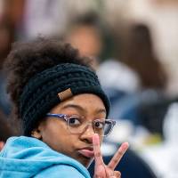 Girls of Color Summit previous event with a girl doing a peace sign